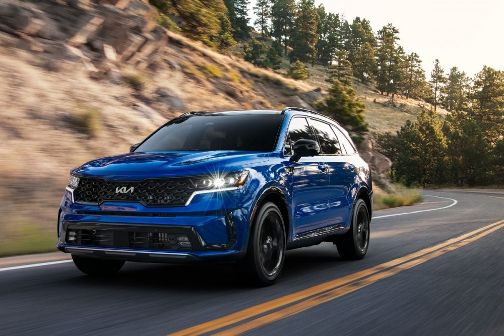 Front view of a blue 2022 Kia Sorento driving on a highway