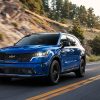 Front view of a blue 2022 Kia Sorento driving on a highway