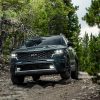 Front view of a green 2022 Kia Sorento traversing a rocky area