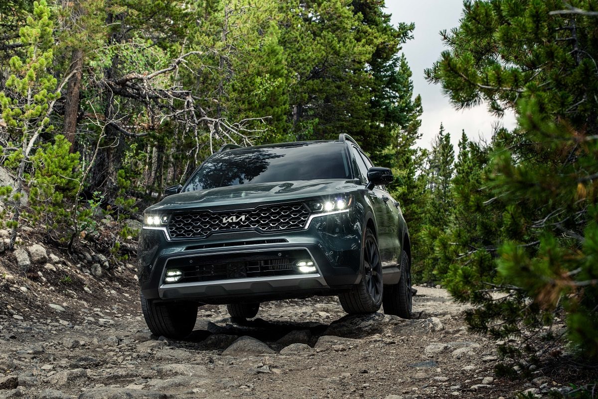 Front view of a green 2022 Kia Sorento traversing a rocky area