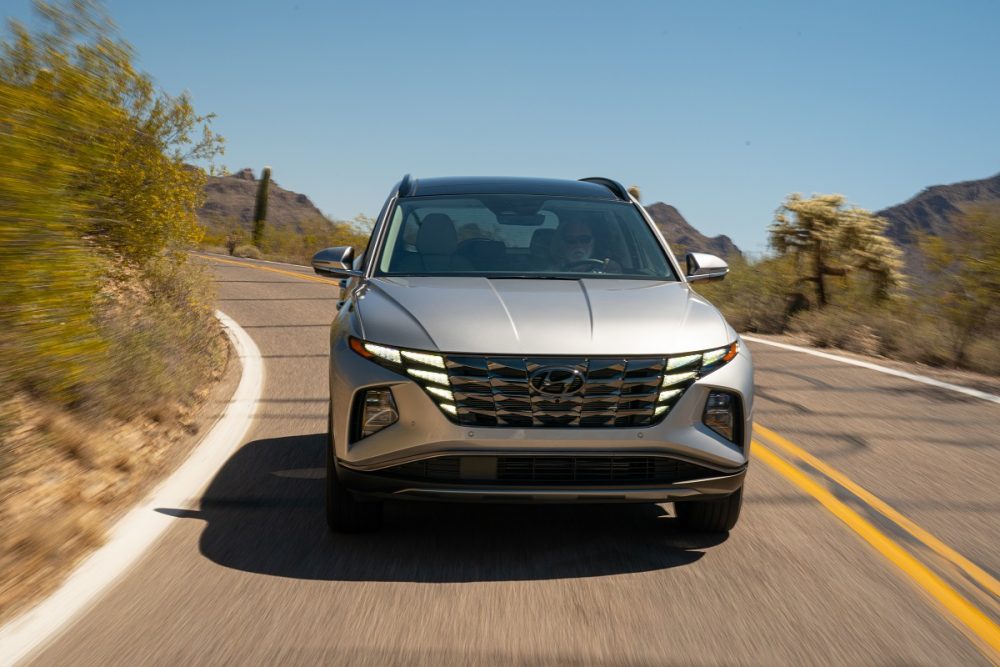 Front view of 2022 Hyundai Tucson Hybrid driving around curve