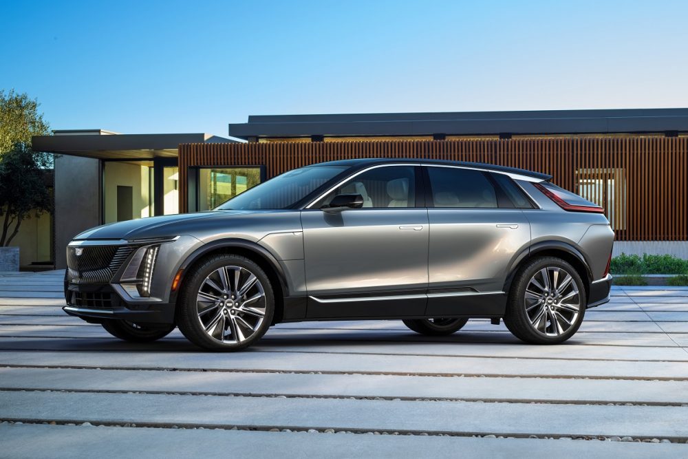 A silver gray 2023 Cadillac Lyriq is parked in front of a modern home