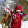 child in winter clothing playing in the snow