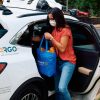 A customer retrieves a grocery bag from the backseat of a Ford Escape Hybrid