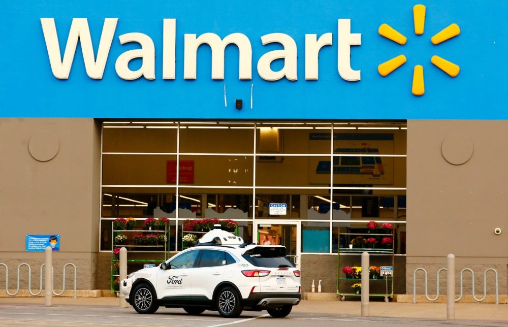 A self-driving Ford Escape Hybrid parked in front of a Walmart