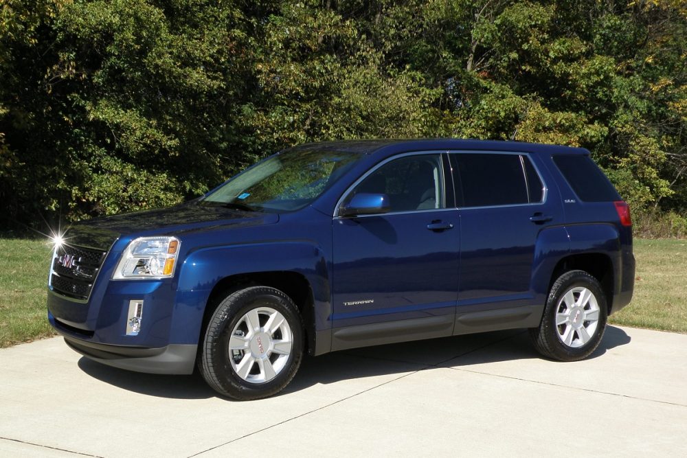 Front side view of a blue 2010 GMC Terrain parked in a residential area