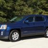 Front side view of a blue 2010 GMC Terrain parked in a residential area