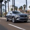 2022 Buick Envision driving down street with palm trees