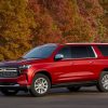 Front side view of parked 2022 Chevrolet Suburban with trees in background