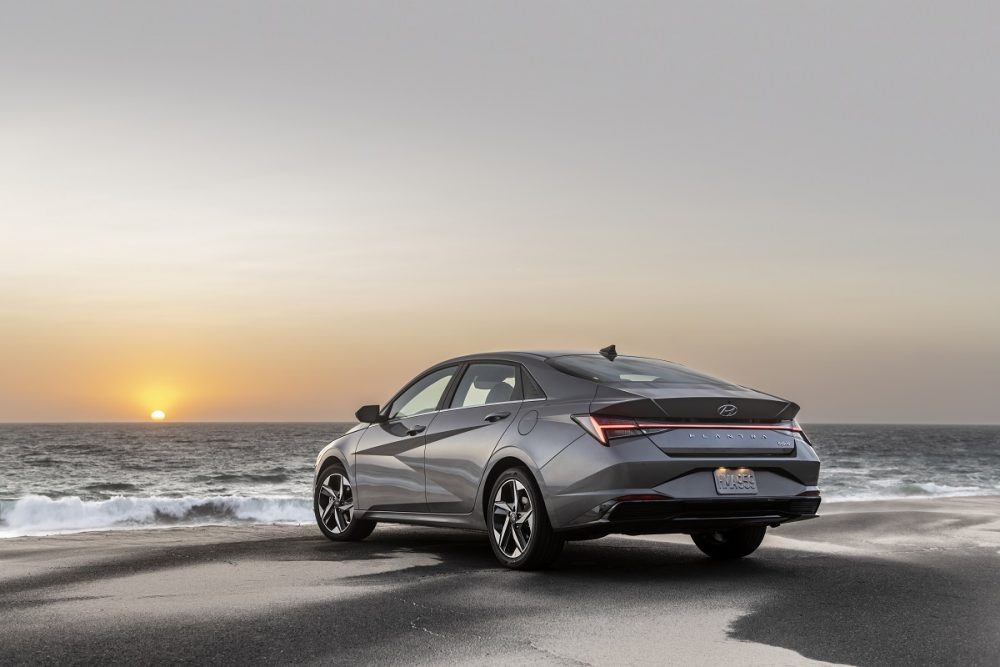 Rear side view of 2022 Hyundai Elantra on beach at sunset