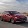 Front side view of red 2022 Hyundai Elantra driving down road