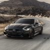 Front side view of 2022 Hyundai Sonata N Line Night Edition driving around curve with hill in background