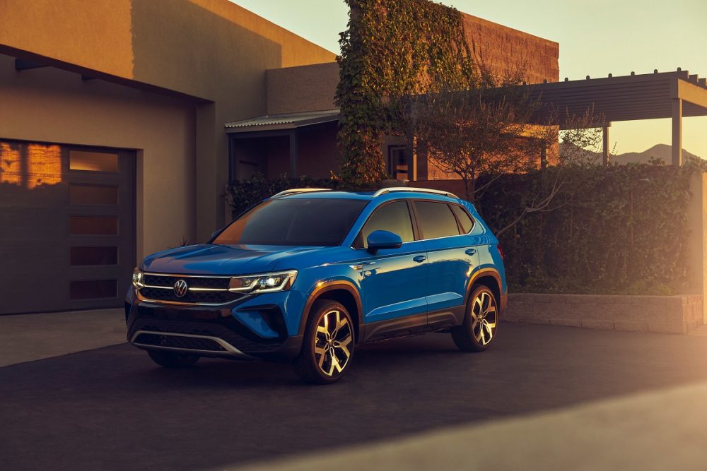 Front view of a blue 2022 Volkswagen Taos parked in front of a house in the desert