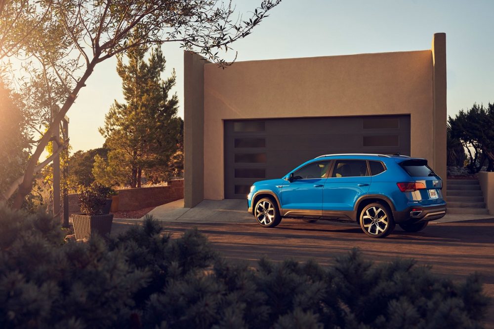 Side view of a blue 2022 Volkswagen Taos parked in front of a house in the desert