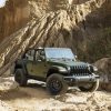 The 2022 Jeep® Wrangler Willys with the Xtreme Recon Package driving over a sandy hill