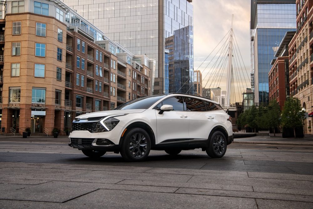 A white 2023 Kia Sportage SX is parked on a city street