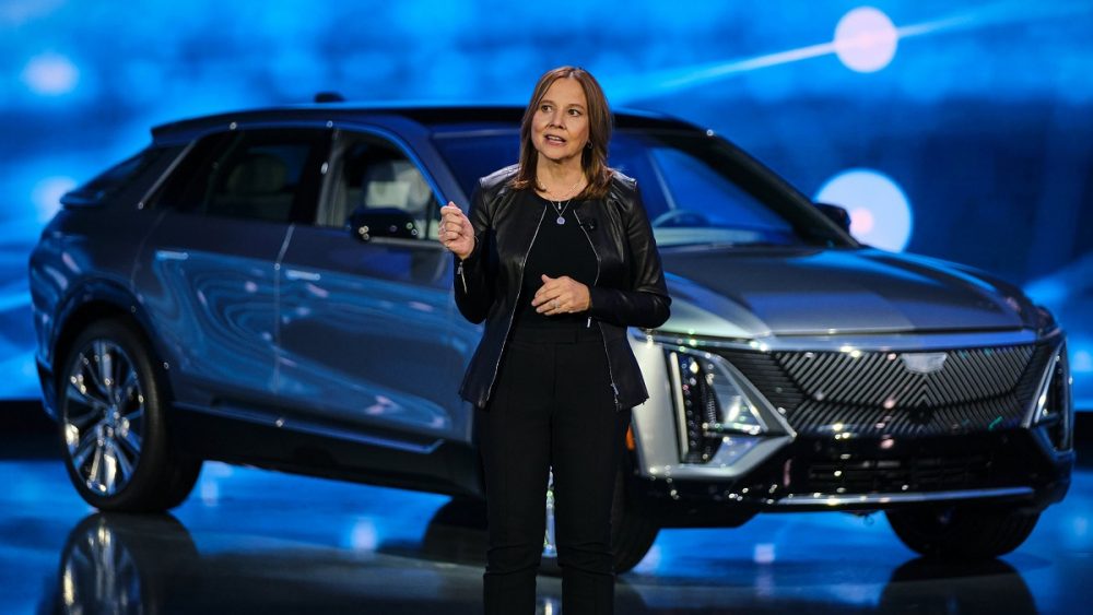 GM Chair and CEO Mary Barra gesturing in front of a Cadillac LYRIQ EV