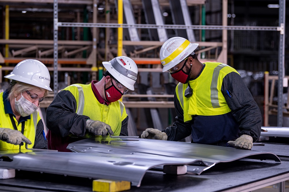 Mazda Toyota Manufacturing employees work on a body panel for 2022 Corolla Cross production