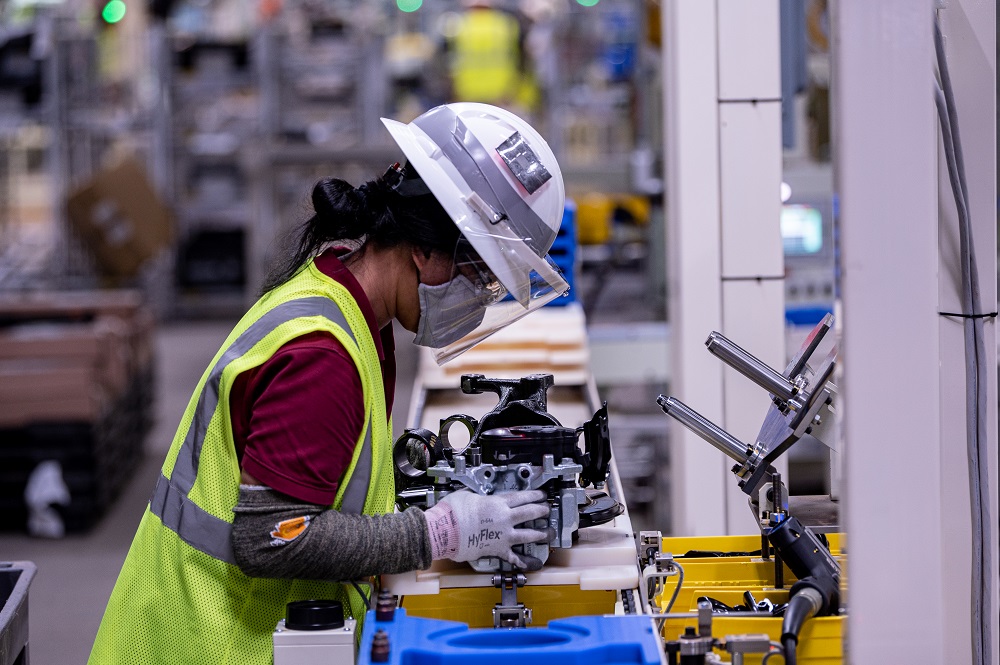 Mazda Toyota Manufacturing employee works on an engine