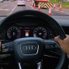 Close up of two hands on an Audi steering wheel with a highway work zone ahead