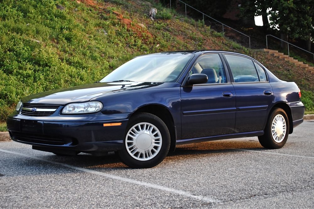 A dark blue 2000 Chevrolet Malibu parked in a parking lot