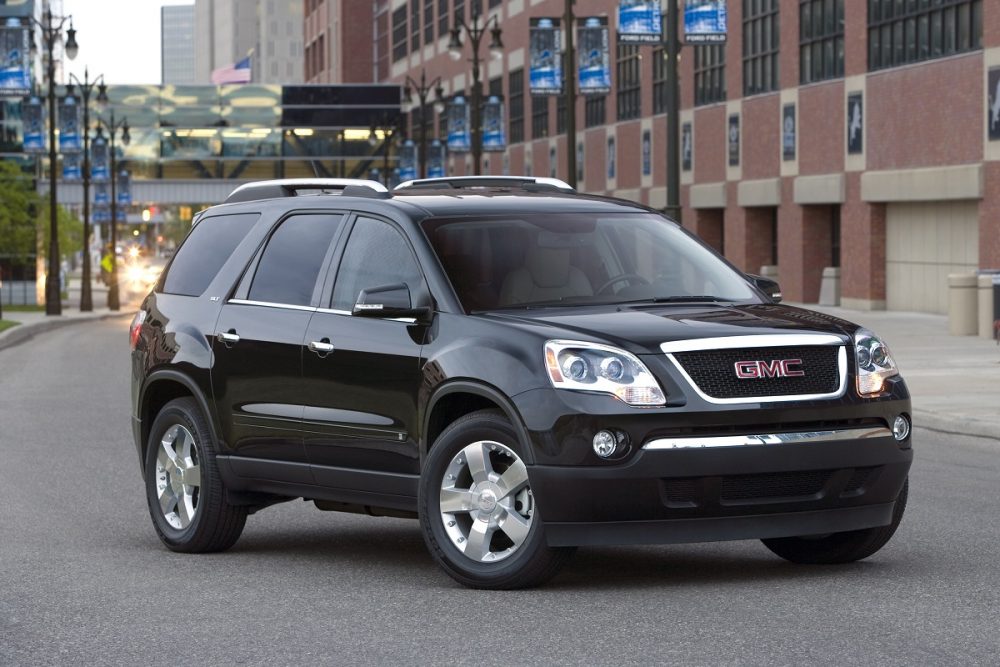 A black 2009 GMC Acadia SLT parked in a city street