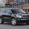 A black 2009 GMC Acadia SLT parked in a city street