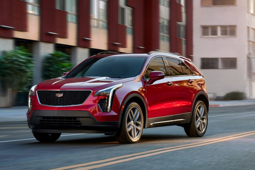 A red 2022 Cadillac XT4 drives along a city street