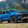 A bright blue 2022 Chevrolet Colorado Trail Boss sits among a mountainous area