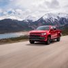 Front side view of 2022 Chevrolet Colorado with Trail Boss package driving down road with mountains in background