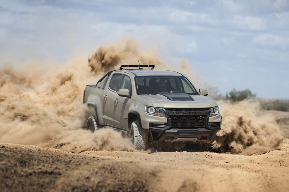 Front side view of 2022 Chevrolet Colorado ZR2 kicking up dust on off-road trail