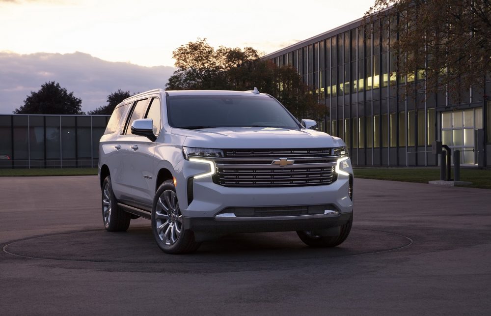 Front view of white 2021 Chevrolet Suburban with lights on