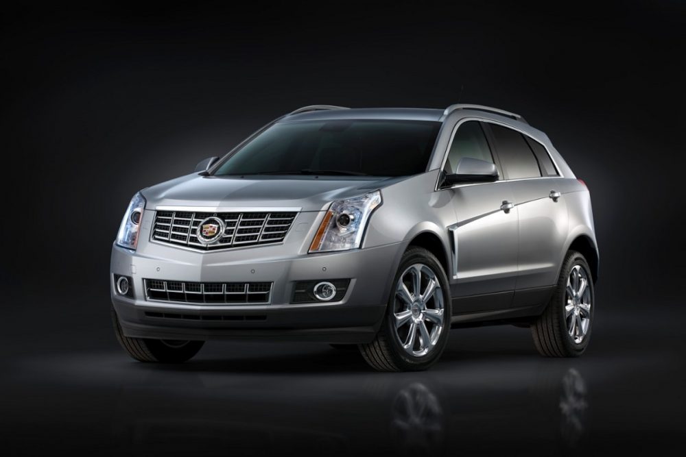 A silver 2016 Cadillac SRX in front of a blank black background