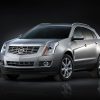 A silver 2016 Cadillac SRX in front of a blank black background