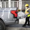 2022 Ford F-150 Lightning pre-production a UAW-represented worker inspects the tailgate of a truck at Rouge Electric Vehicle Center