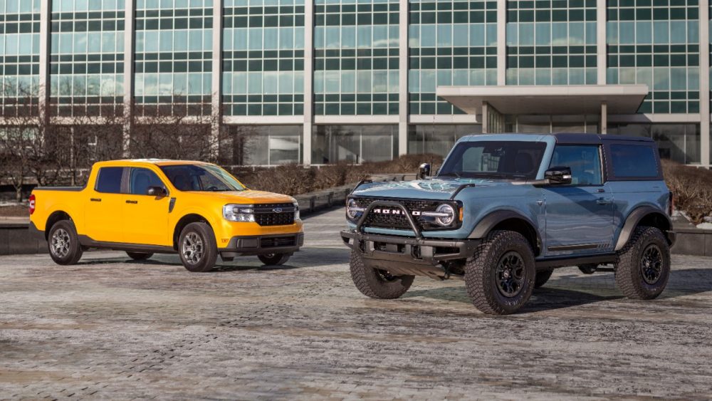 A 2022 Ford Maverick and Ford Bronco pose in front of Ford World Headquarters in Dearborn after winning the 2022 North American Truck of the Year and North American Utility of the Year awards