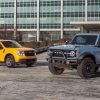 A 2022 Ford Maverick and Ford Bronco pose in front of Ford World Headquarters in Dearborn after winning the 2022 North American Truck of the Year and North American Utility of the Year awards