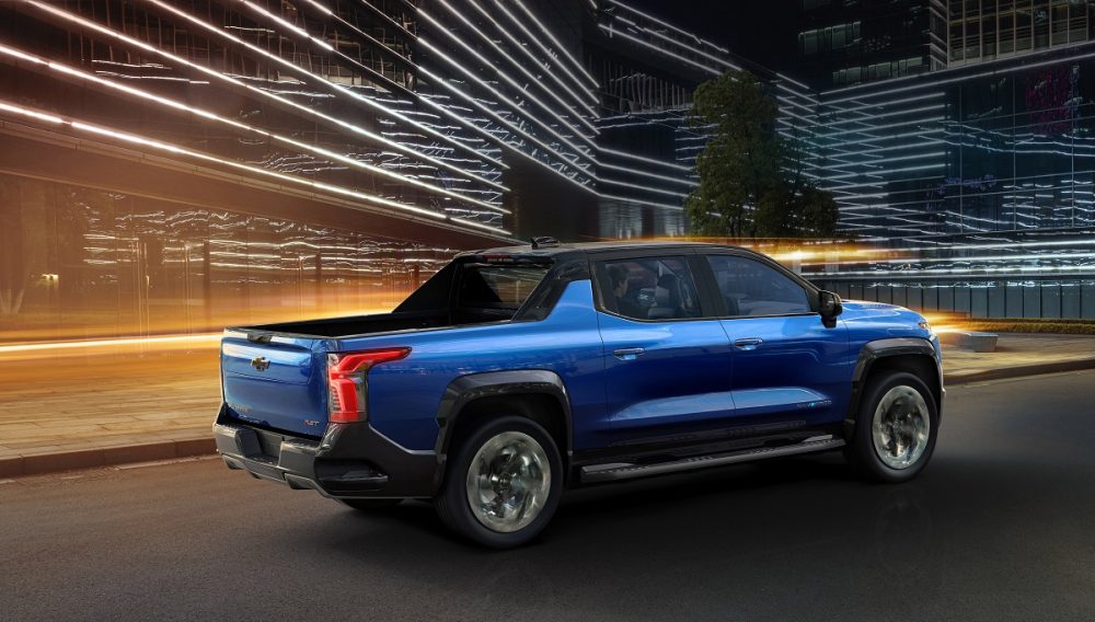 Rear side view of 2024 Chevrolet Silverado EV RST driving at night