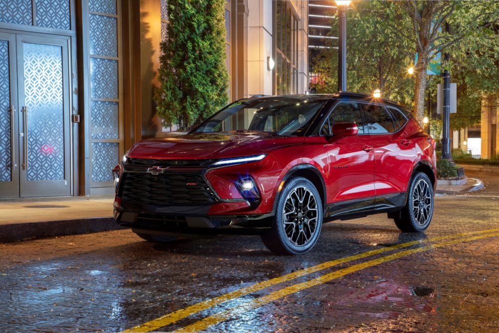 front and side view of red 2023 Chevrolet Blazer RS parked on city street at night