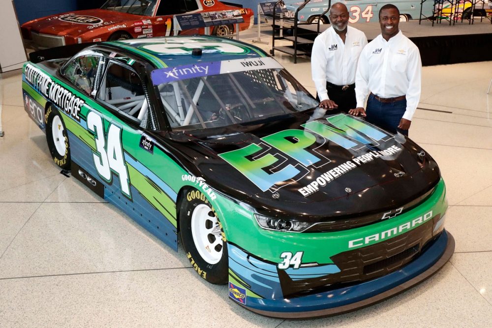Jesse Iwuji and Emmitt Smith pose by the Number 34 Empowering People More Chevy Camaro SS