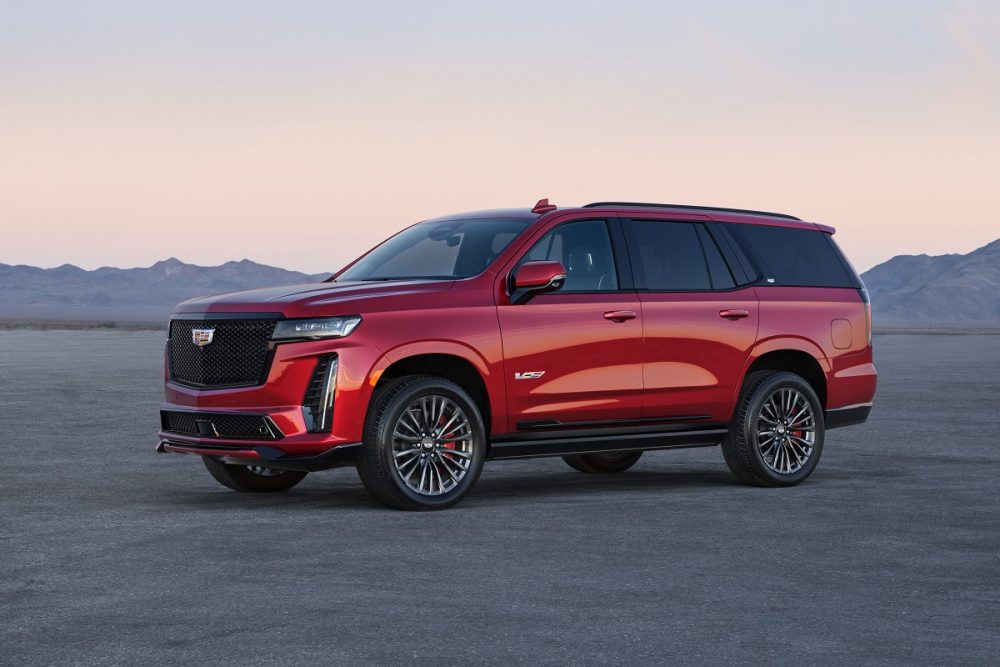 Side view of a red 2023 Cadillac Escalade-V in front of mountains