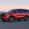 Side view of a red 2023 Cadillac Escalade-V in front of mountains