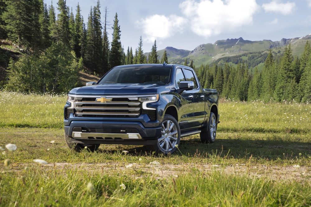 Front side view of 2022 Chevrolet Silverado High Country with forest and mountains in background