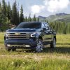 Front side view of 2022 Chevrolet Silverado High Country with forest and mountains in background