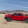 Side view of red 2022 Chevrolet Silverado ZR2 driving up desert hill