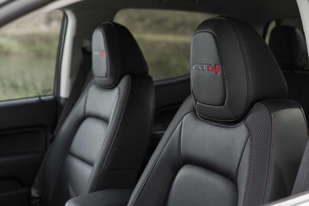 Close-up view of 2022 GMC Canyon AT4 front bucket seats with embroidered headrest logos