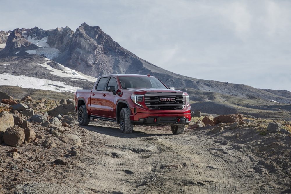 Front side view of red 2022 GMC Sierra AT4X with mountains in background