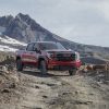 Front side view of red 2022 GMC Sierra AT4X with mountains in background