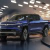 Blue 2024 Chevrolet Silverado EV parked at night in front of a building