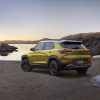 Rear side view of yellow 2023 Chevrolet Trailblazer ACTIV parked with lake in background